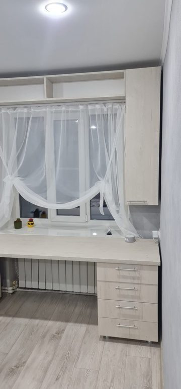 белый стол и навесные полки в детской комнате
