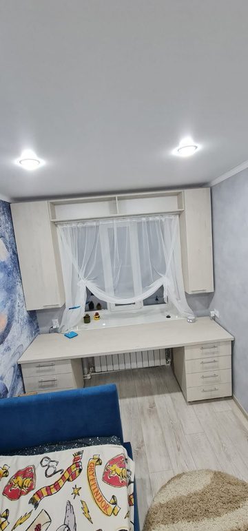 белый стол и навесные полки в детской комнате